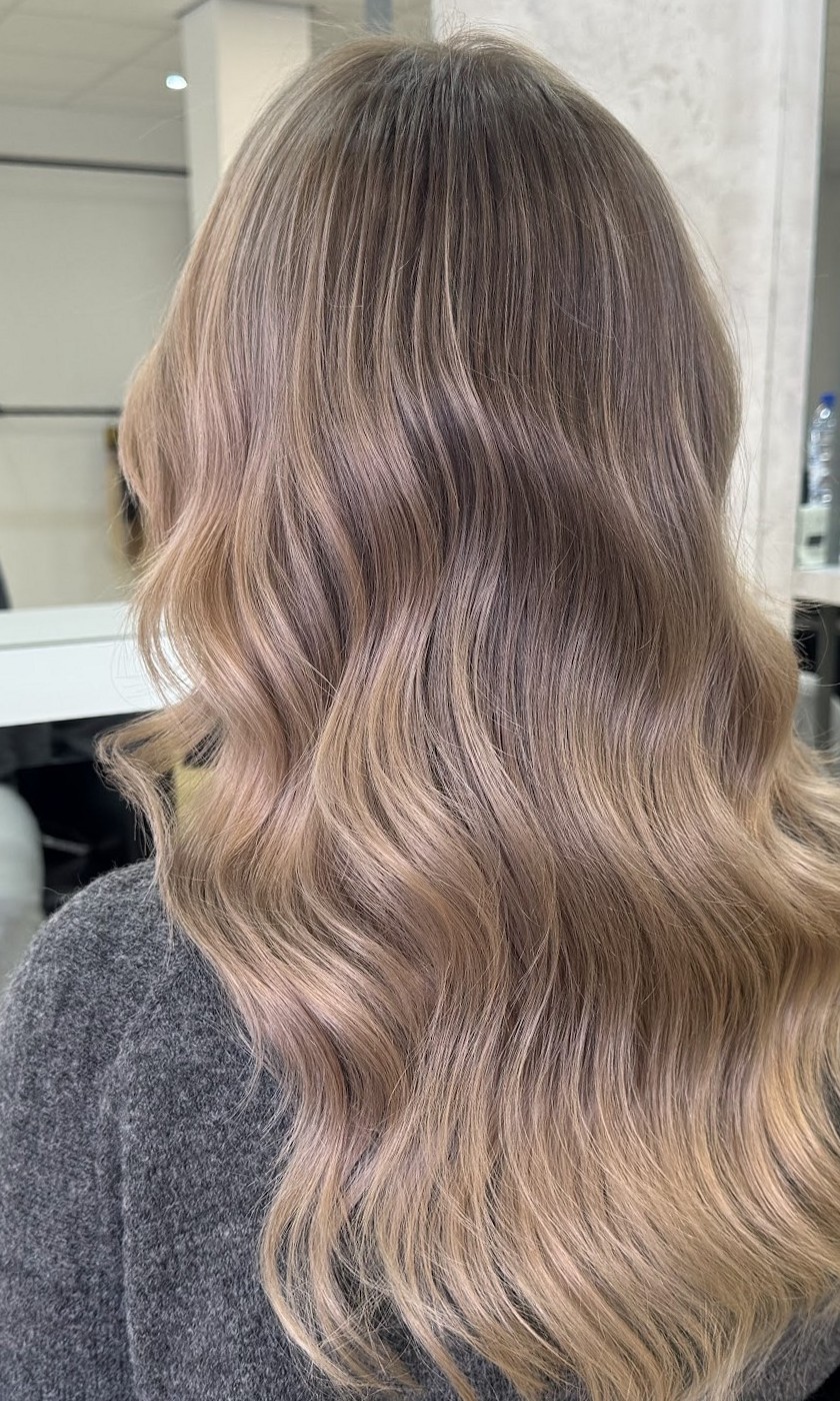 Asblonde golven in de salon, met de spiegels en stoelen op de achtergrond