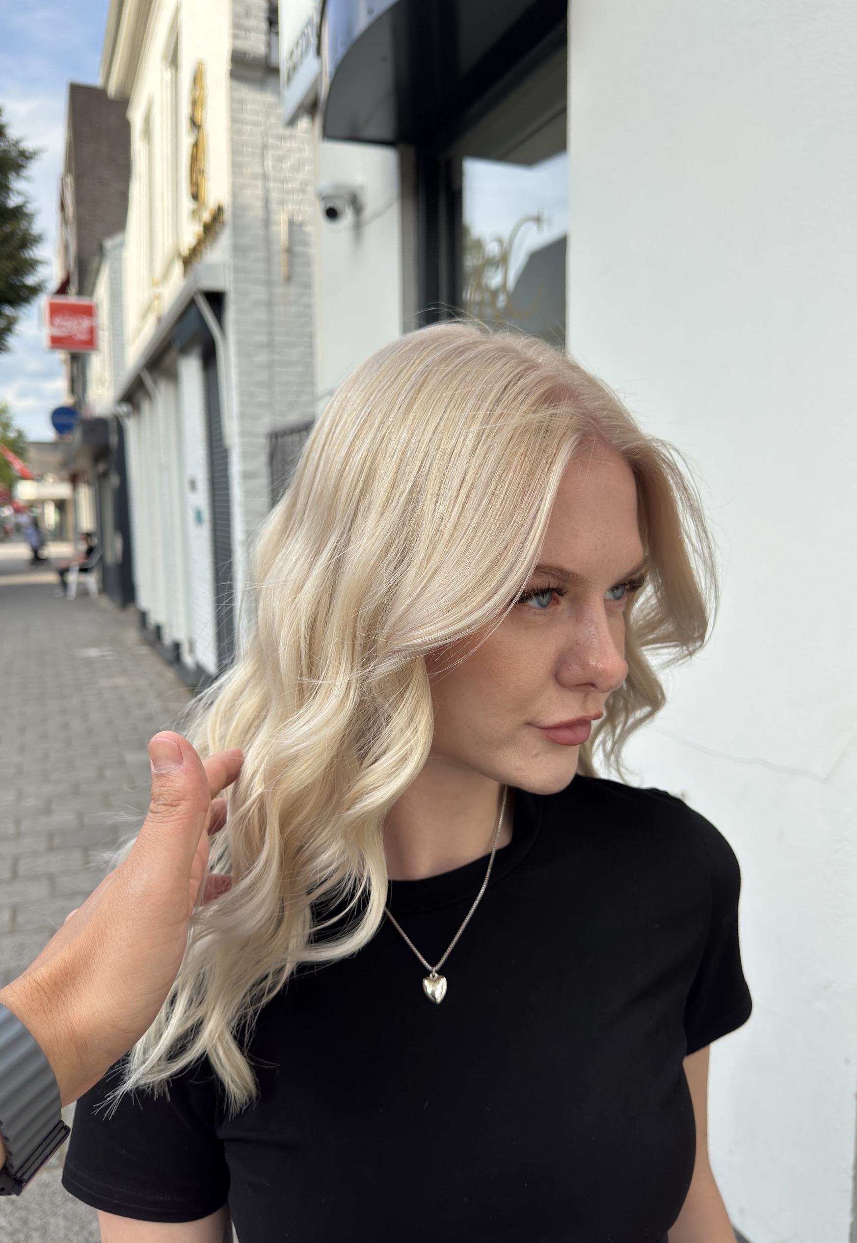 Platinablonde golven, buiten op de Stationsstraat voor de salon